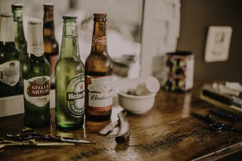 Three Assorted Beverage Bottles on Brown Wooden Table