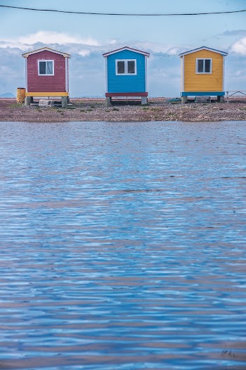 Three Assorted-color Wooden Mini Houses Facing Sea