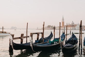 three black gondola boats on sea