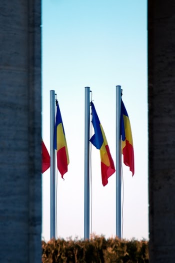 Three Blue-yellow-and-red Flags on Gray Pole