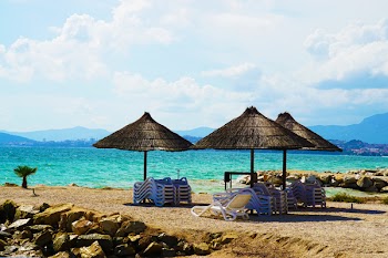 Three Brown Parasols on Seashore