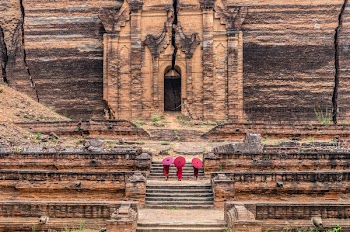 Three Buddhist novice are walking and holding the red umbrella at Mingun Pahtodawgyi, bagan, mandalay, myanmar, public domain