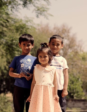 Three Children Standing Beside Tree