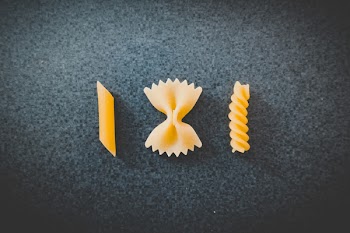 Three Different Pieces of Macaronis on Top of Black Surface