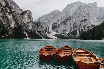 three docked boats facing mountains during daytime