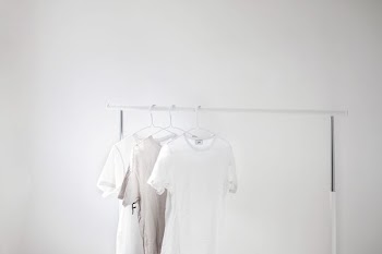 three gray and white crew-neck t-shirts on cloth drying rack