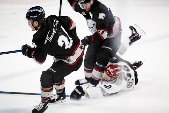 Three Ice Hockey Players Playing Hockey