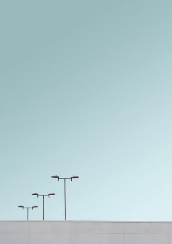 three light posts under clear skies