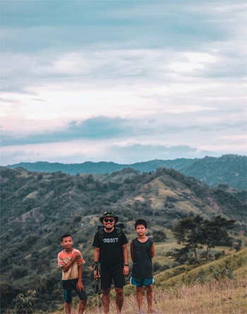 Three Man Taking Photo With Mountains at Distance