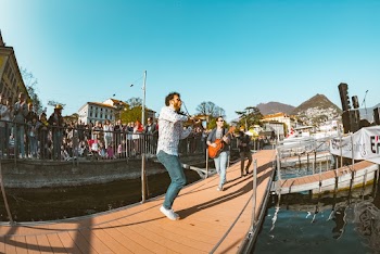 Three Men Playing Instruments on Boardwalk