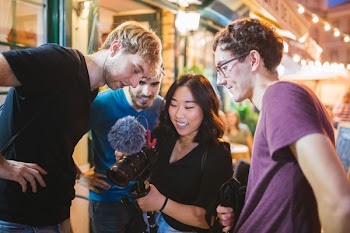 Three Men Watching Camera Holding by a Woman