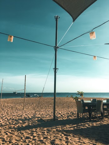 Three Pendant Lamps Near Dining Table Set Viewing Calm Sea and Seashore