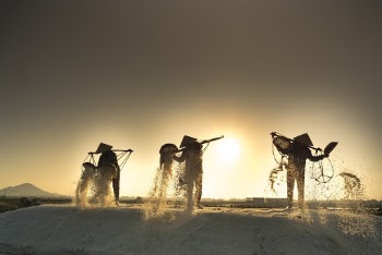 Three People Carrying Poles