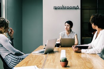 Three People Discussing Inside the Conference Room