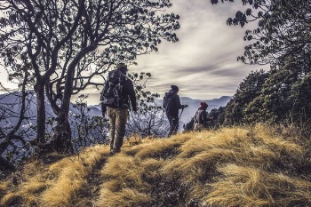 Three People Hiking on High Mountain