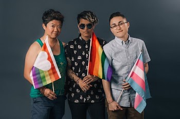 Three People Holding Pride Flags