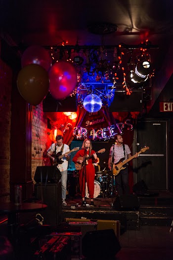 Three People Playing Musical Instruments On The Stage