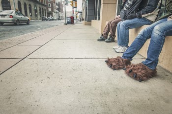 Three People Sitting Beside Road