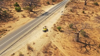 Three People Standing Near Yellow Car