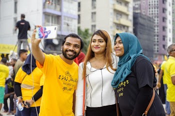 Three People Standing While Taking Pictures