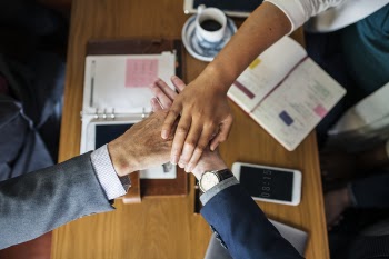 Three Person's Hands on Center Near Table