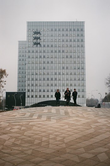 Three Person Walking on Concrete Pavement