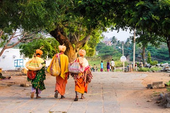 Three Person Walking on Concrete Road