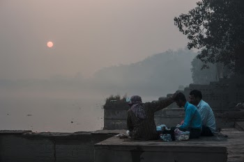 Three Persons Sitting on Ground
