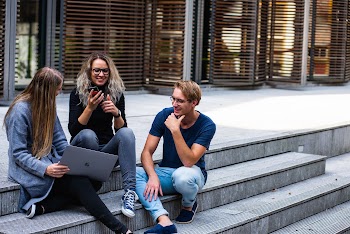 Three Persons Sitting on the Stairs Talking With Each Other · Free Stock Photo