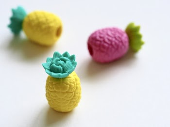 Three Plastic Pineapple Figures on White Surface