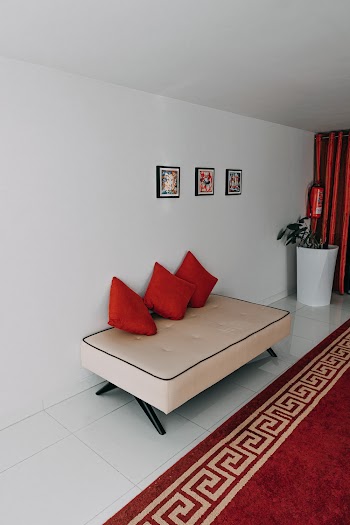 Three Red Throw Pillows on White Sofa in Room