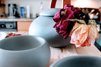Three Round Teal Ceramic Jars on Brown Wooden Table Near Pink and Purple Petaled Flowers