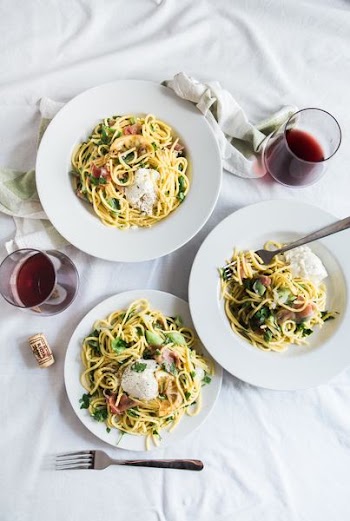 three round white plates with pasta near two glass cuups