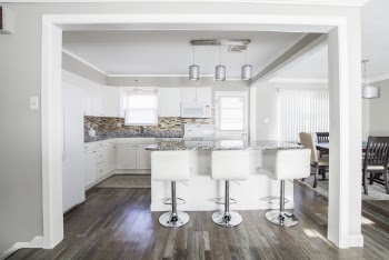 Three White Barstools in Front of Kitchen Island