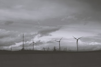 Three Wind Mills Under Cloudy Sky