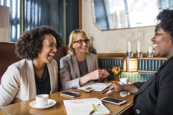 Three Woman Sitting Smiling Inside Room
