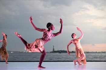Three Women Dancing Near Body of Water