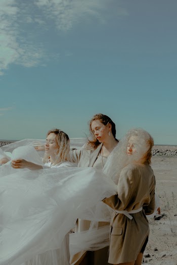 Three Women Holding a Textile