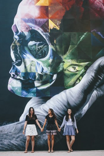 Three Women Standing Near Wall