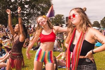 Three Women Standing on Ground With Crowd