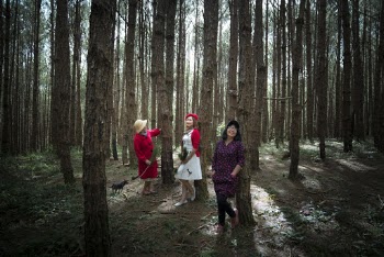 Three Women Standing Under Trees