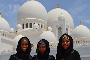 Three Women Taking A Photo In Front Of White Mosque