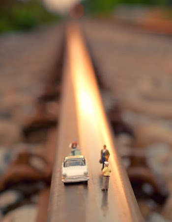 Tilt Shift Lens Photography of White Car and Group of Toy People