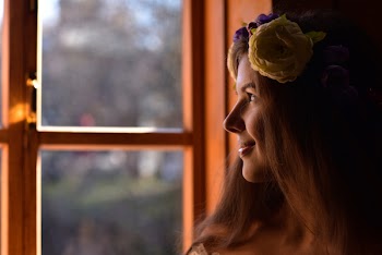 Tilt Shift Lens Photography of Woman Standing Beside Clear Glass Window