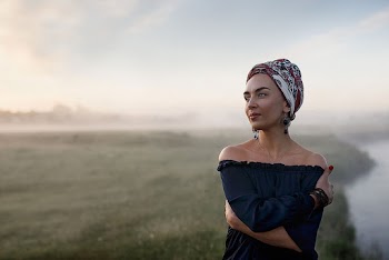 Tilt-shift Lens Photography of Woman Standing Near Body of Water