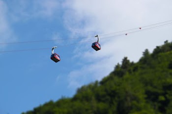 tilt shift photography of two red cable line transports at daytime