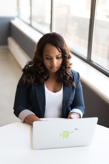 Tilt-shift Photography of Woman in Blue Formal Coat With White Laptop Computer