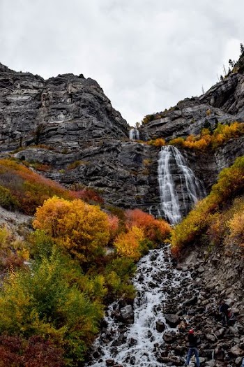 time laps photography of plunge waterfalls under cumulus clouds