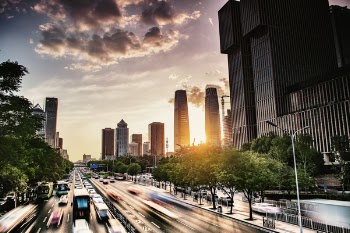 Time Lapse Photo of Vehicles on Street Near Building at Sunset
