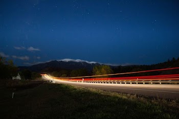 time lapse photograph of train under starry sky